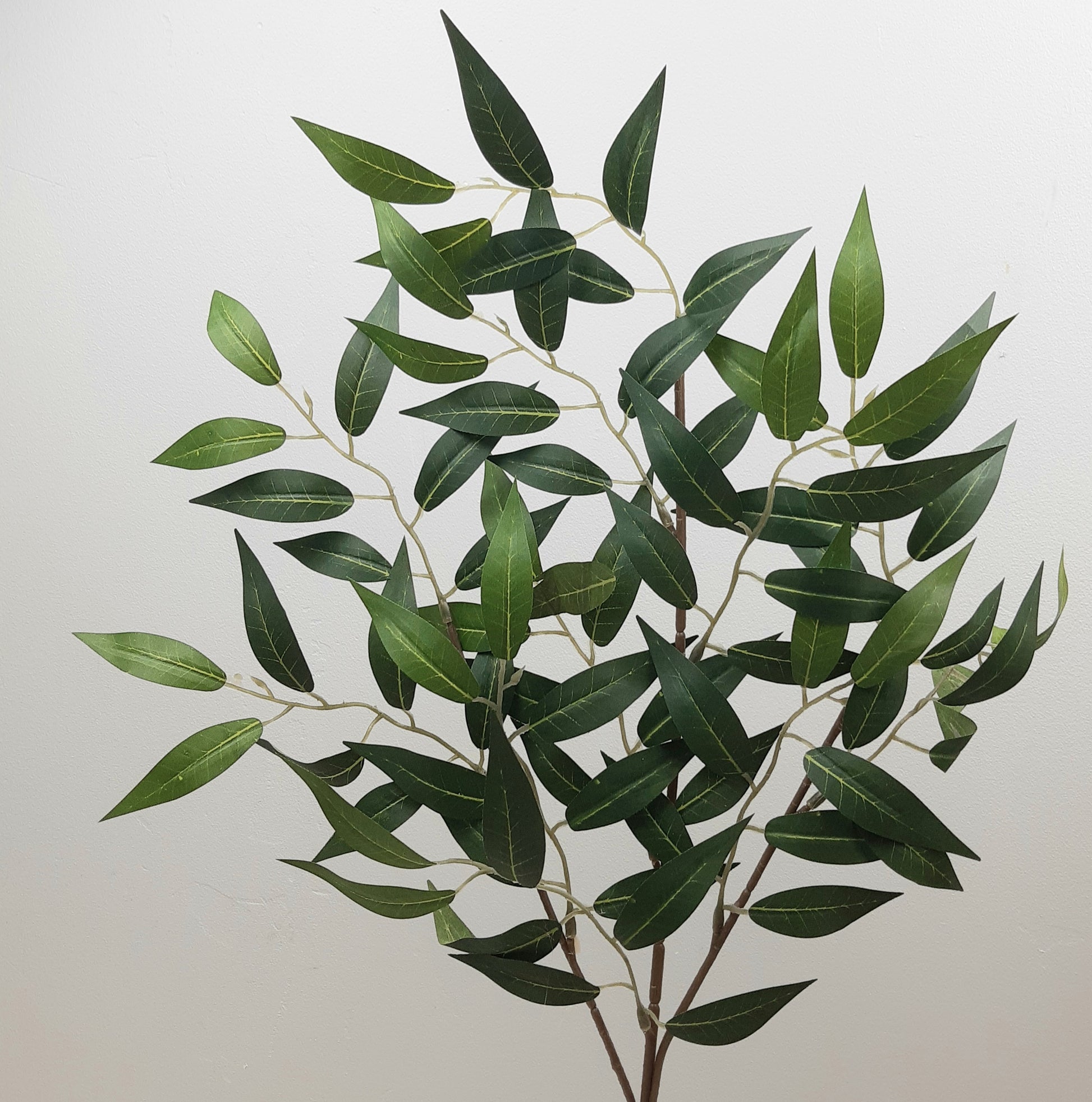 A 68cm artificial green Ruscus spray with lifelike leaves, suitable for floral arrangements and decorations.