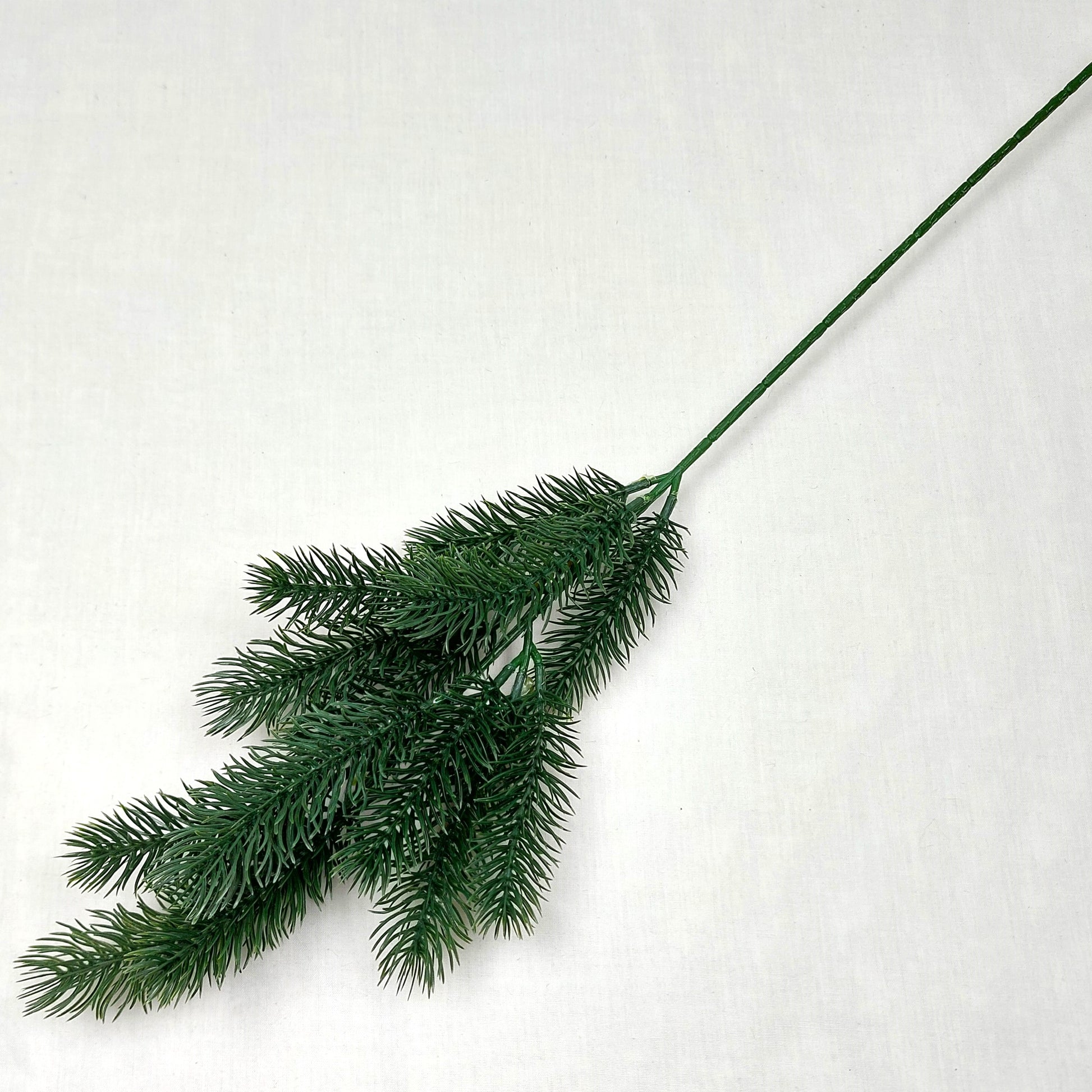 Artificial green Spruce branch on a white background