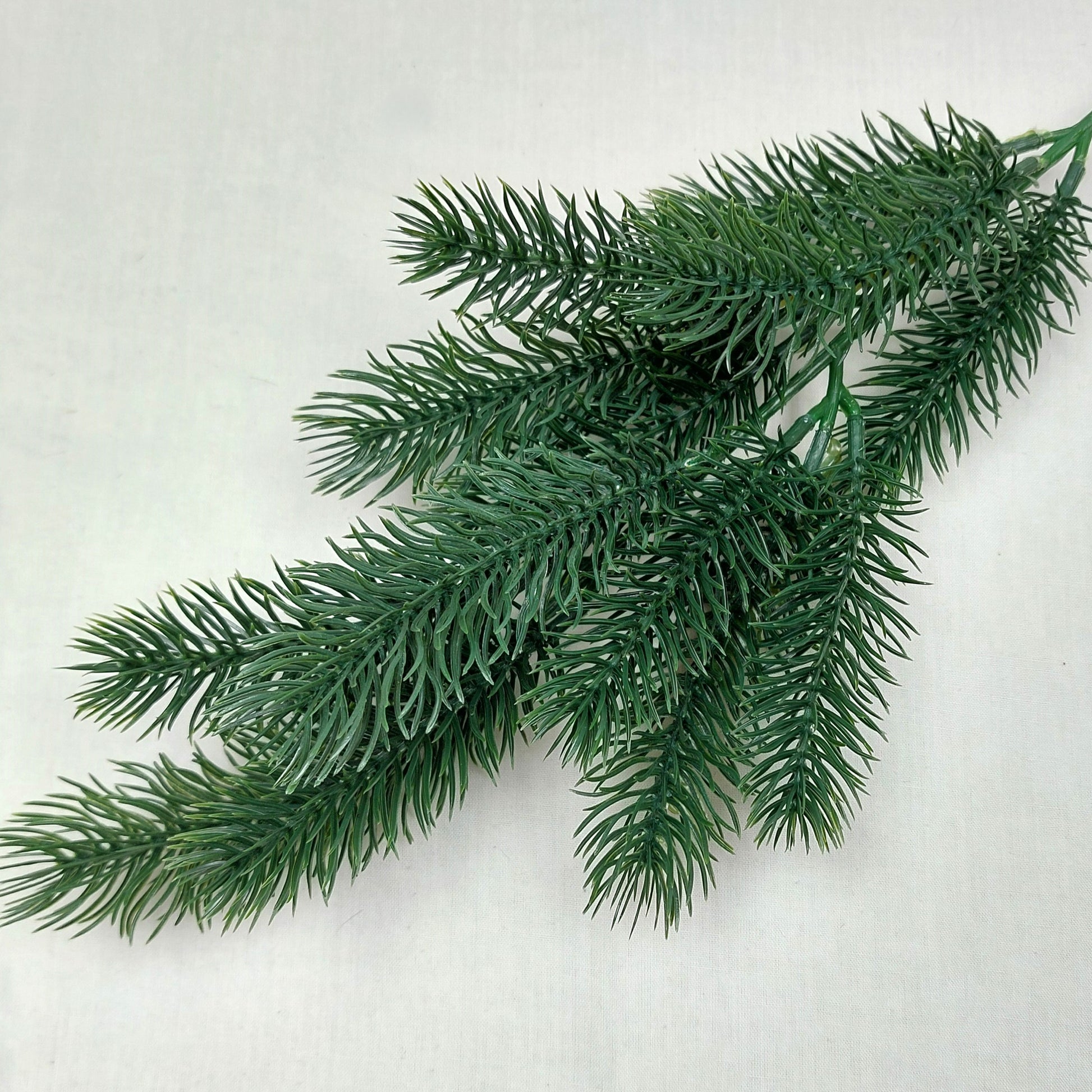 Close up of Artificial green Spruce pine branch on a white background