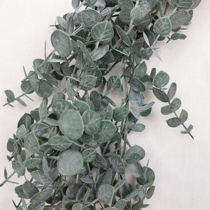 Close up of Artificial eucalyptus leaves on a garland on a white background