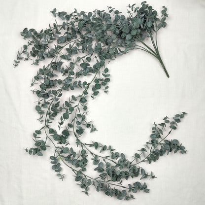 Artificial green eucalyptus leaves on a white background