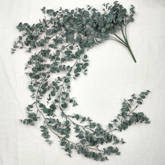 Artificial green eucalyptus leaves on a white background