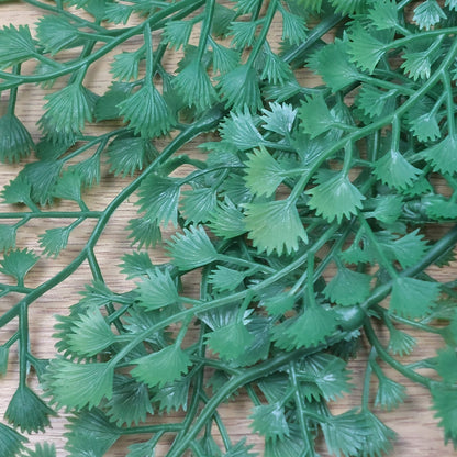 Close-up of green artificial leaves on a wooden surface