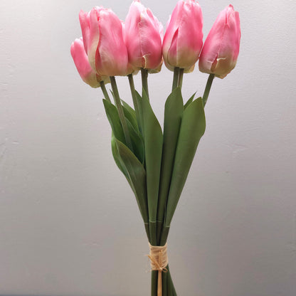 A bunch of artificial Pink Tulips against a pale background