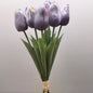 A bunch of artificial Purple Tulips against a pale background