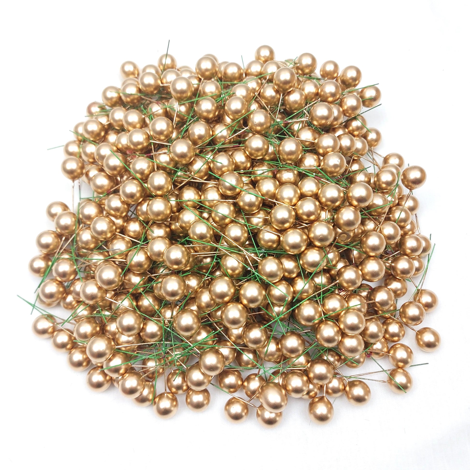 A large collection of faux wired gold berries on a white background