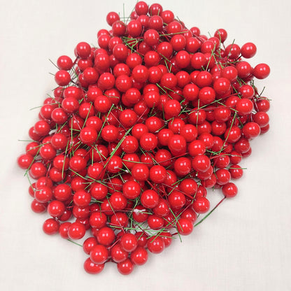 A large quantity of faux red berries on a white background