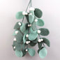 Decorative mistletoe felt hanging swag with green leaves and white berries on a light gray background