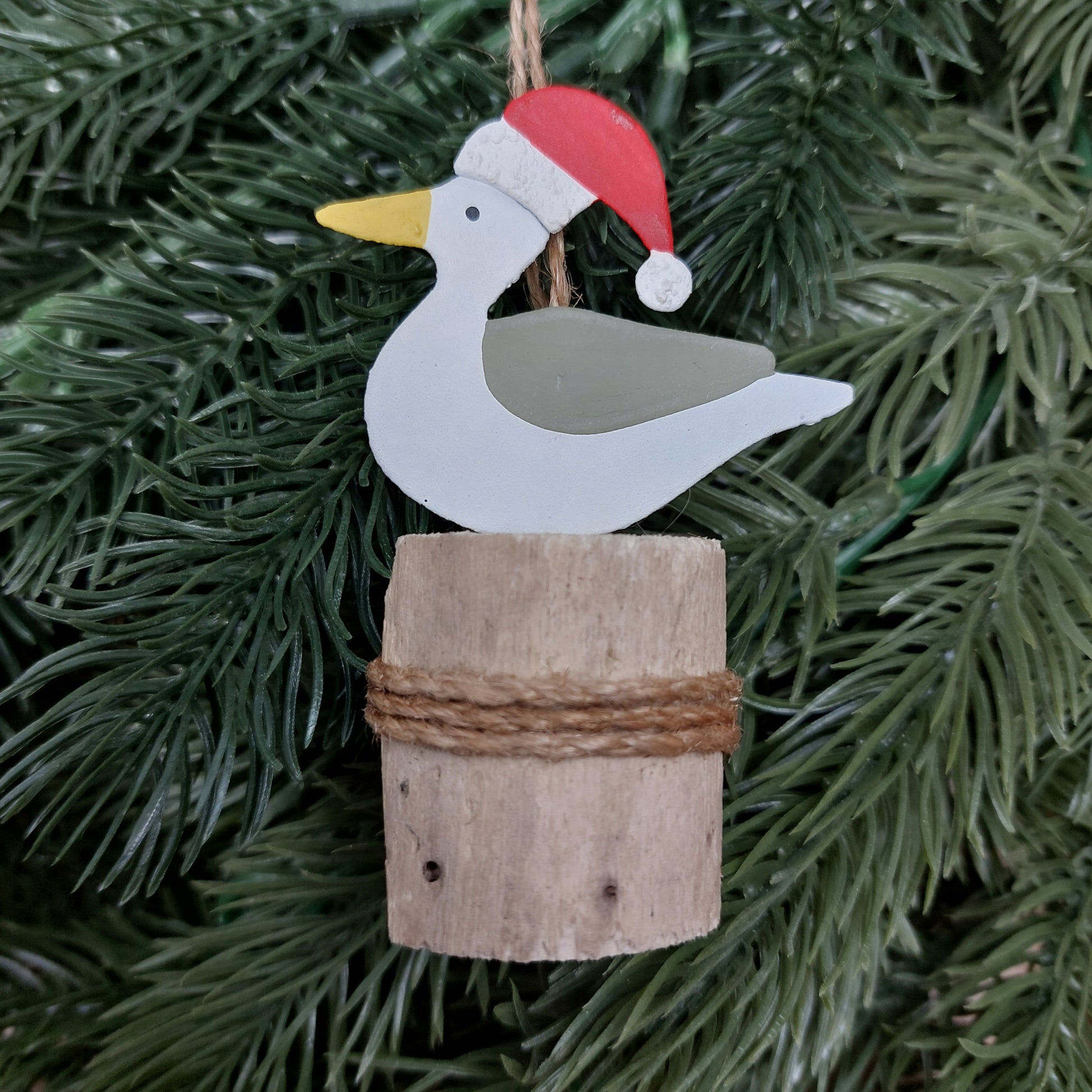 Metal seagull with a wooden base on a Christmas tree.