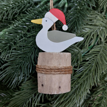 Metal seagull with a wooden base on a Christmas tree.