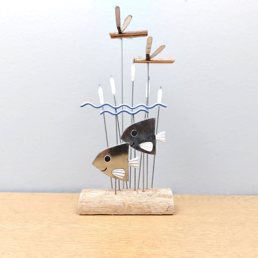 Decorative ornament with a fish design on a wooden base against a light gray background