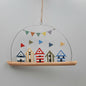 Hanging decoration with colorful beach huts and bunting on a plain background