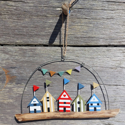 Decorative hanging with beach hut and flag bunting garland design on a wooden surface