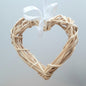 A hanging Natural Colour Wicker Heart with a white satin ribbon and bow.