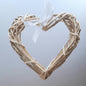 A hanging Natural Colour Wicker Heart with a white satin ribbon and bow.
