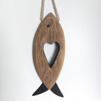 Wooden rustic style fish-shaped ornament with a heart cutout on a white background