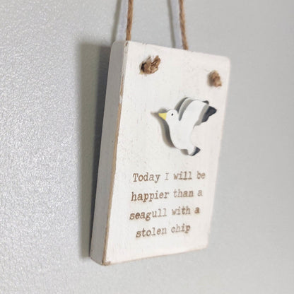 Wooden whitewashed sign with a seagull illustration and humorous text on a white background