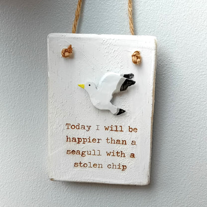 Decorative whitewashed style wooden sign with a seagull and humorous motivational text on a plain background