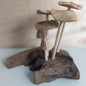 Handmade Wooden mushroom figurines on a piece of driftwood with a blurred background
