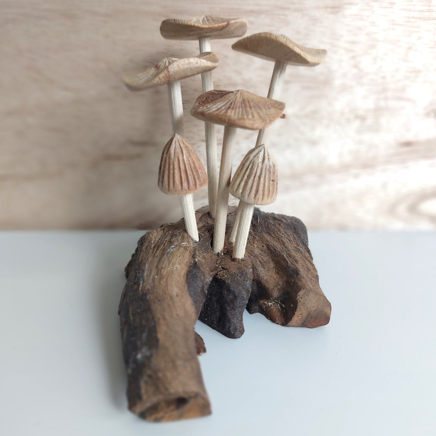 Indonesian Decorative arrangement of wooden mushrooms on a natural wood base with a blurred background