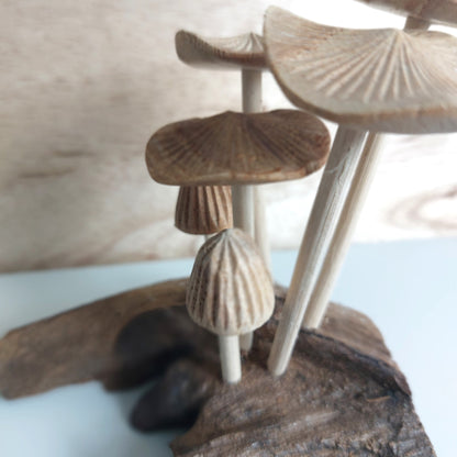 Hand Carved Decorative arrangement of wooden Mushrooms and driftwood on a neutral background