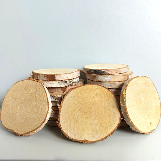 Stack of wooden birch log slices on a light gray background