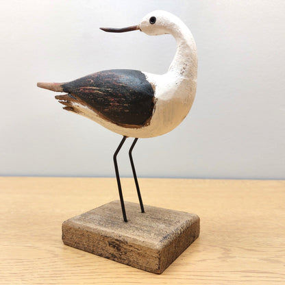 Wooden Oystercatcher on a wooden plinth against a grey background