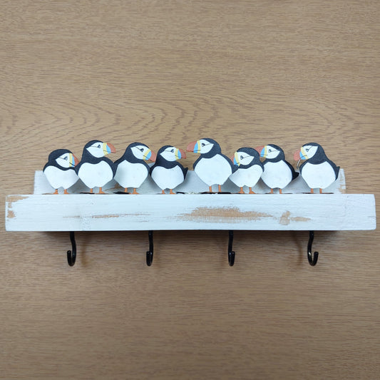 Decorative key holder with puffin designs on a wooden background
