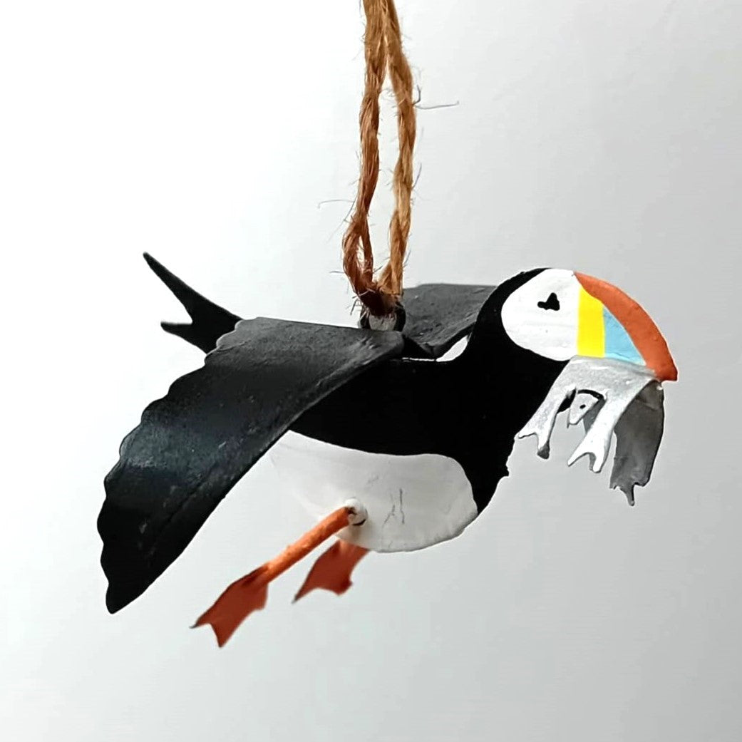 Decorative puffin bird ornament hanging on a string against a white background