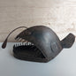 Decorative metal angler fish sculpture on a wooden surface