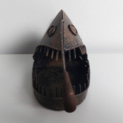 Decorative metal angler fish object on a white background