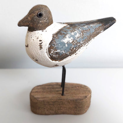 Decorative Sanderling bird figure on a wooden base against a white background