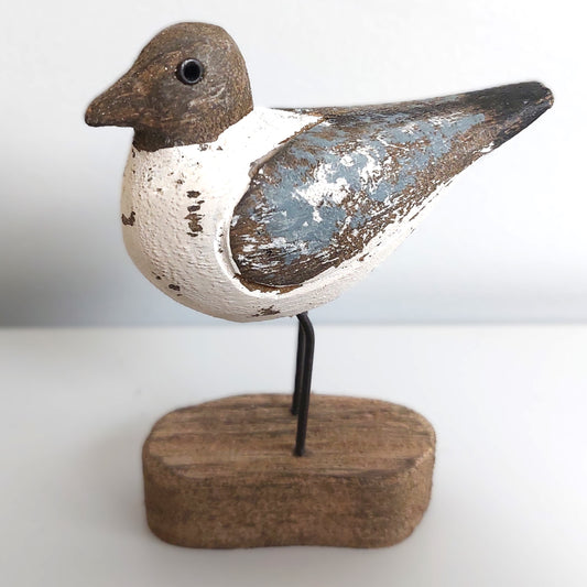 Decorative Sanderling bird figure on a wooden base against a white background
