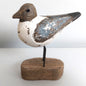 Decorative Sanderling bird figure on a wooden base against a white background