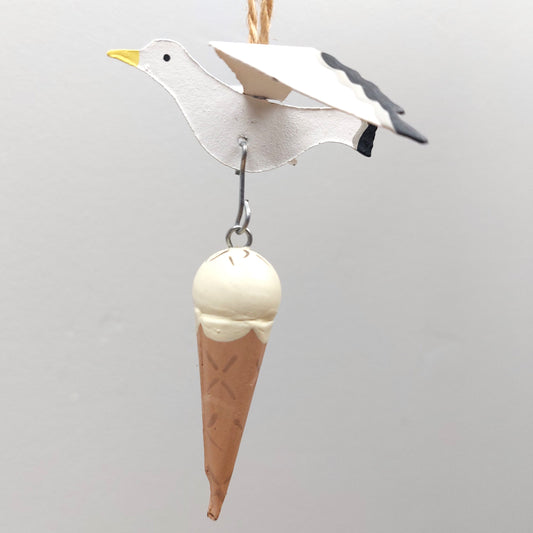 A metal painted Seagull holding an ice cream cone against a plain background