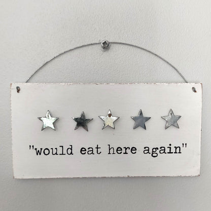 Decorative white wooden sign with five stars and text 'would eat here again' on a white background