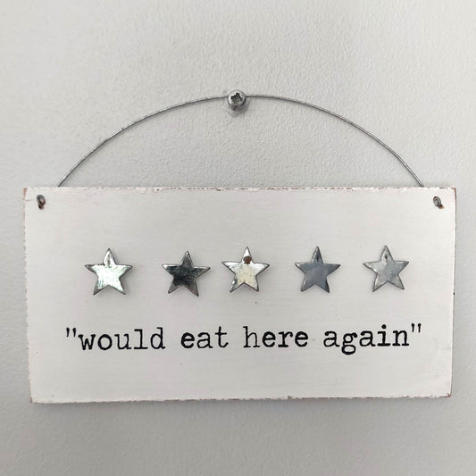 Decorative white wooden sign with five stars and text 'would eat here again' on a white background