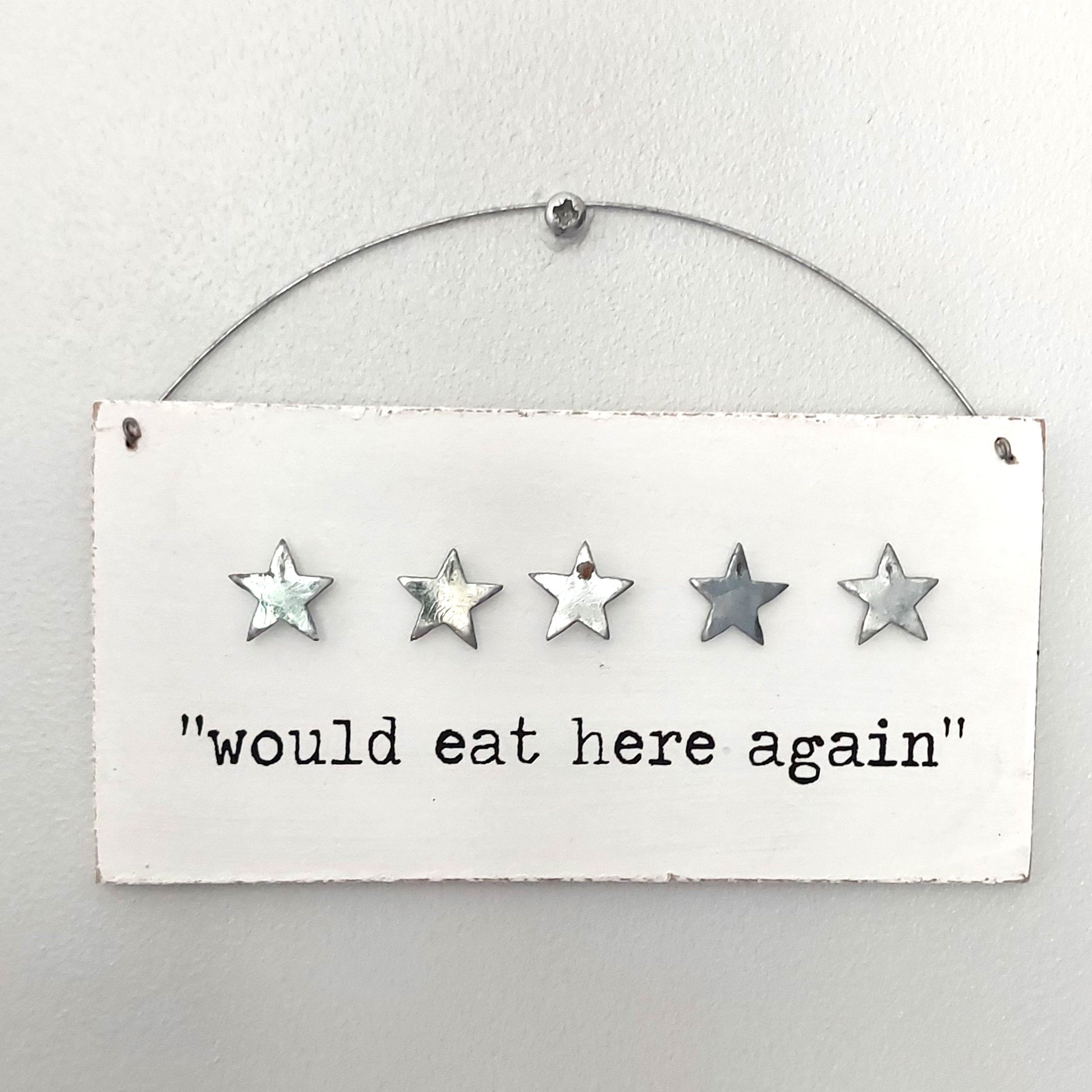 Five-star rating sign with 'would eat here again' text on a white background