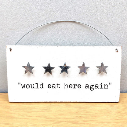Five-star rating sign with 'would eat here again' text on a white background