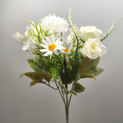 An artificial flower bouquet featuring white roses, white daisies with yellow centers, and green foliage, set against a plain light gray background.