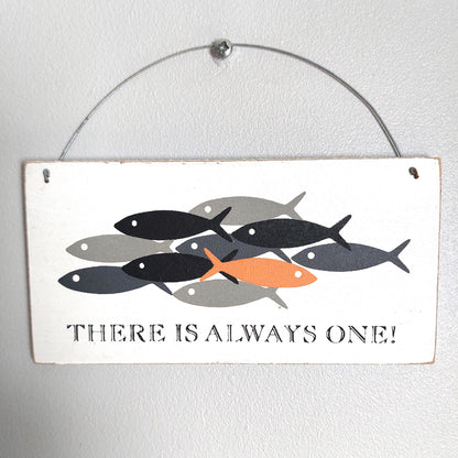 A rectangular white washed hanging wall sign with a metal wire hanger. The sign features a graphic of stylized fish in black, gray, and orange, with the text 'THERE IS ALWAYS ONE!' printed below.