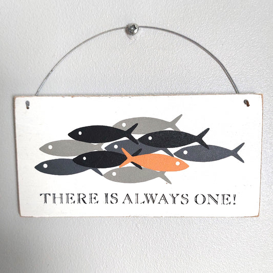 A rectangular white washed hanging wall sign with a metal wire hanger. The sign features a graphic of stylized fish in black, gray, and orange, with the text 'THERE IS ALWAYS ONE!' printed below.