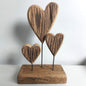 Wooden heart-shaped sculpture on a stand with a plain background