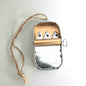 Metallic tin of 3 sardines peering out on a white background