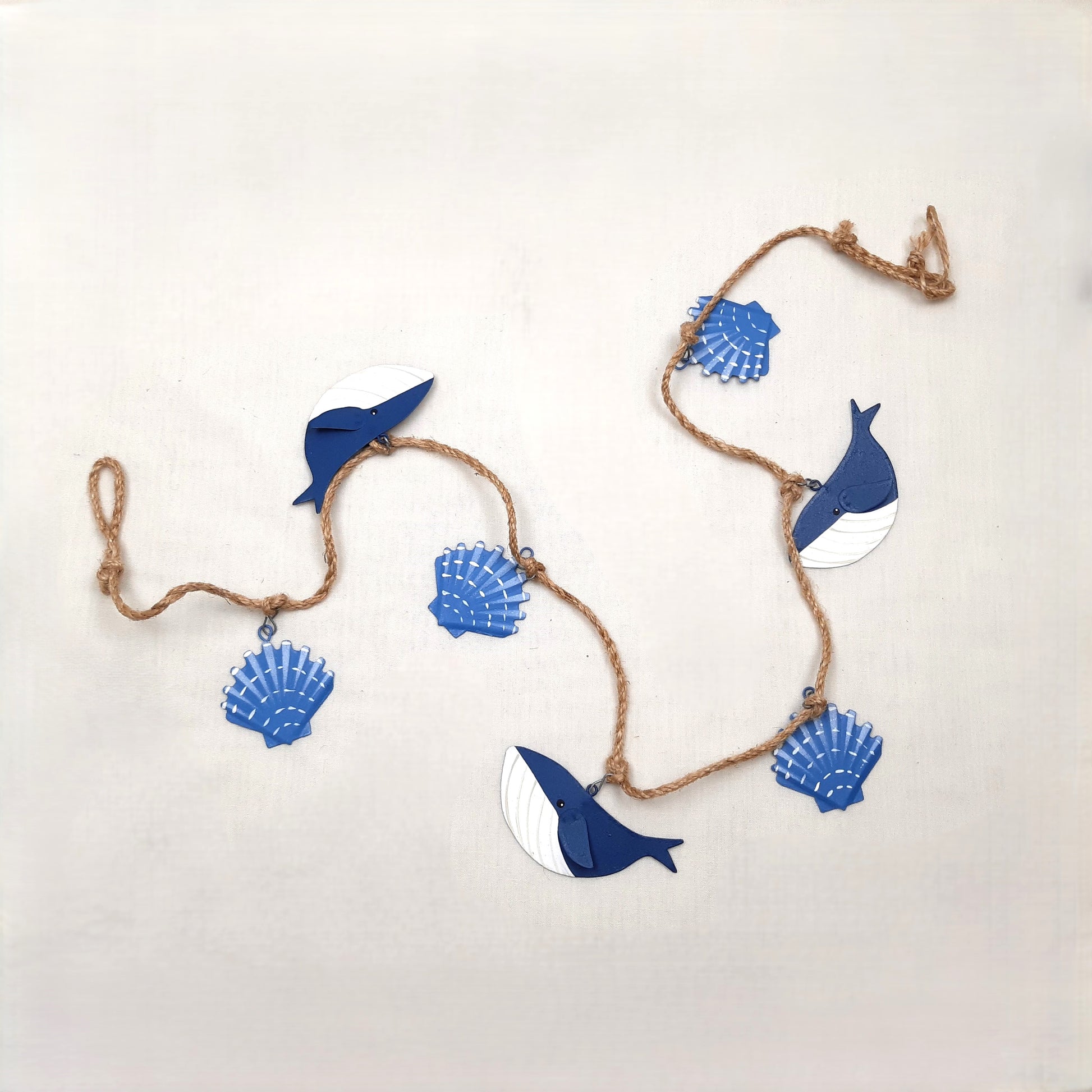 Decorative string with blue whale and shell shapes on a white background