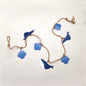 Decorative string with blue whale and shell shapes on a white background