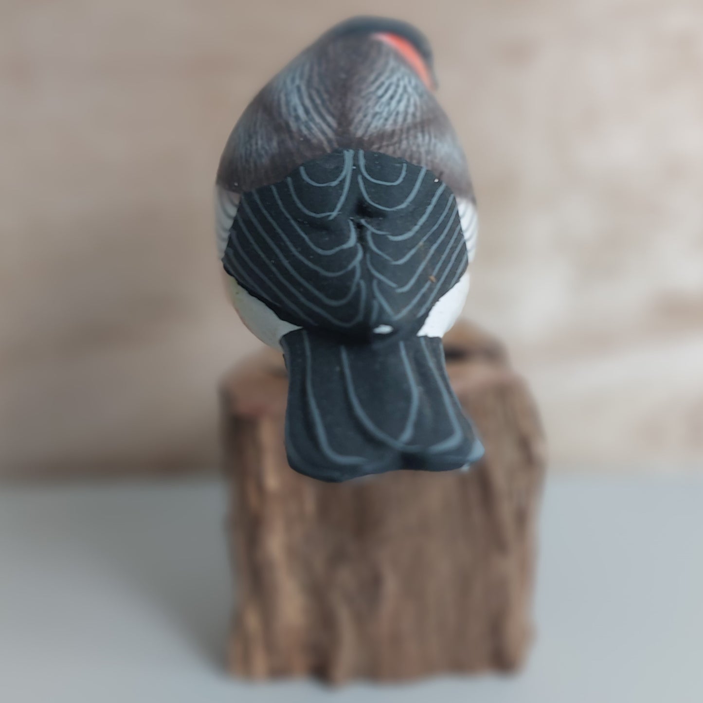 Wooden bird figurine on a natural wooden base made in Bali with a blurred background
