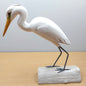 White Egret Wader bird figurine on a wooden base against a plain background