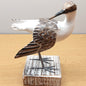 A hand carved and painted wooden Godwit Bird figurine, mounted on a wooden black against a wooden and pale background.