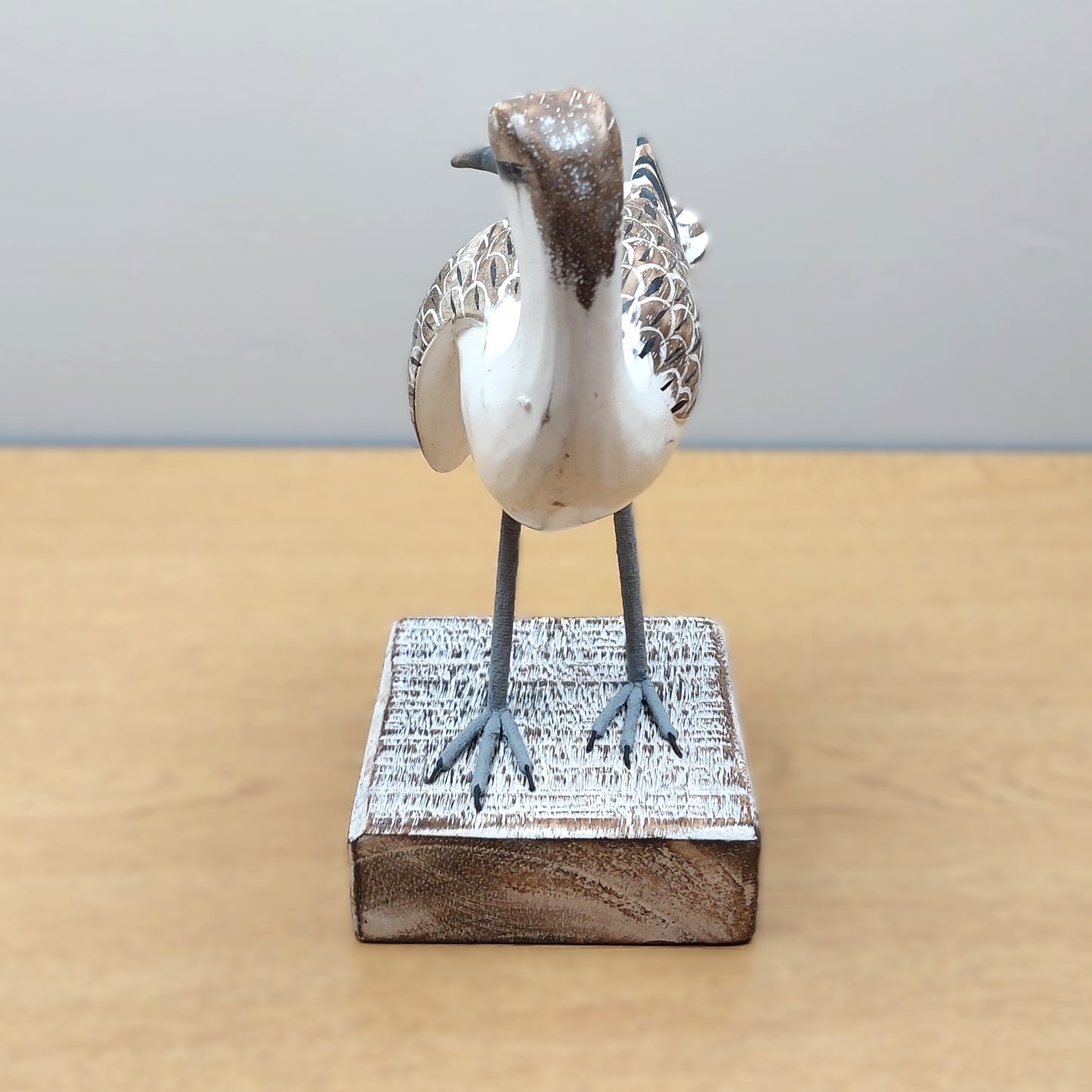 Decorative Godwit bird sculpture made in Bali on a wooden base with a plain background